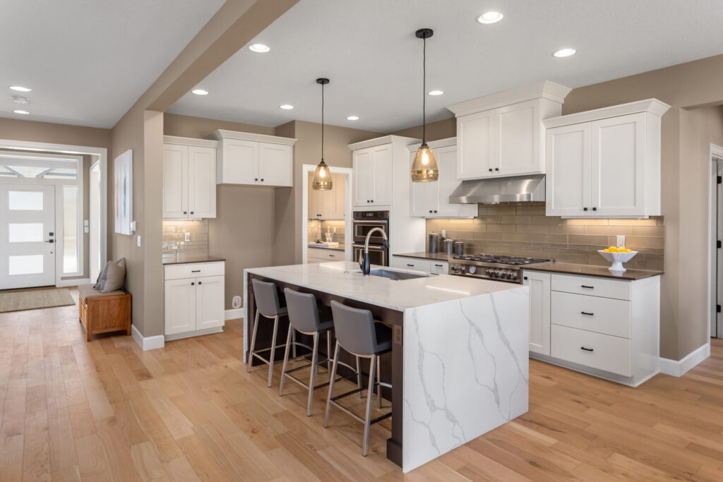 Marble waterfall island with black counter stools, kitchen remodeling by Heritage Remodelers serving Grapevine, TX