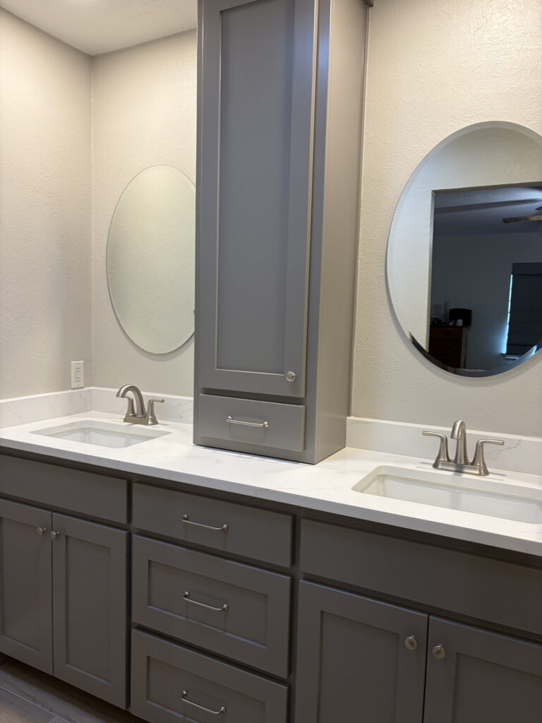 Gray double vanity with quartz top and linen tower, bathroom remodeling by Heritage Remodelers serving Grapevine, TX