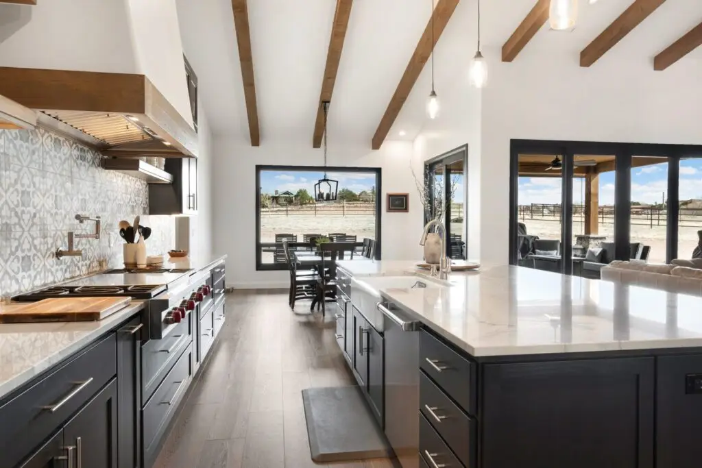 Kitchen with dark cabinets, patterned tile backsplash and wood-beam ceiling