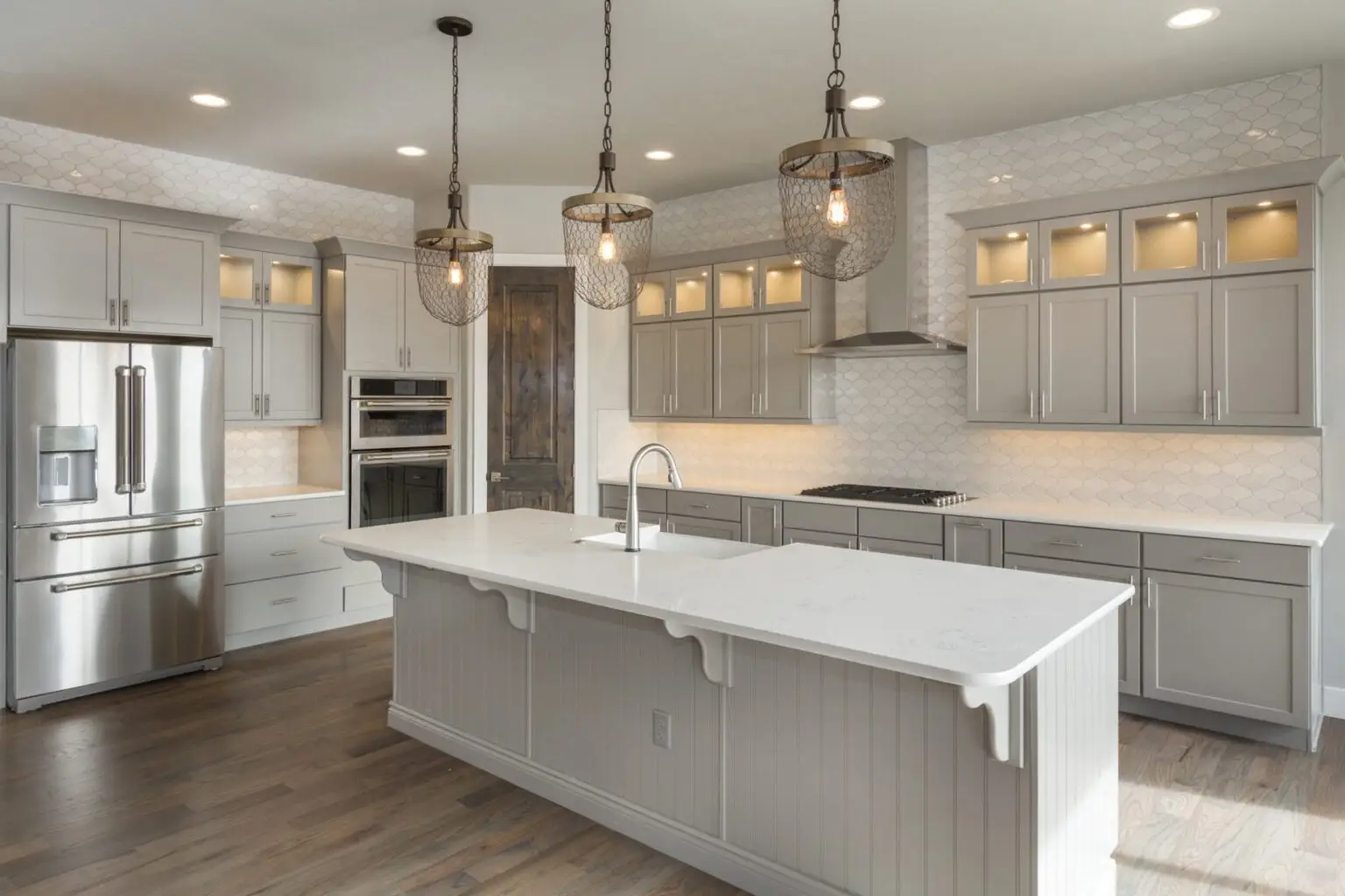 Gray shaker kitchen with quartz island, glass-front uppers and wire pendant lights, kitchen remodel in DFW