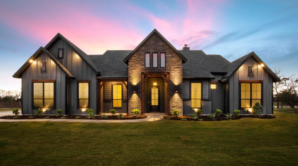 Home additions in DFW: modern farmhouse exterior with stone and board-and-batten siding at dusk