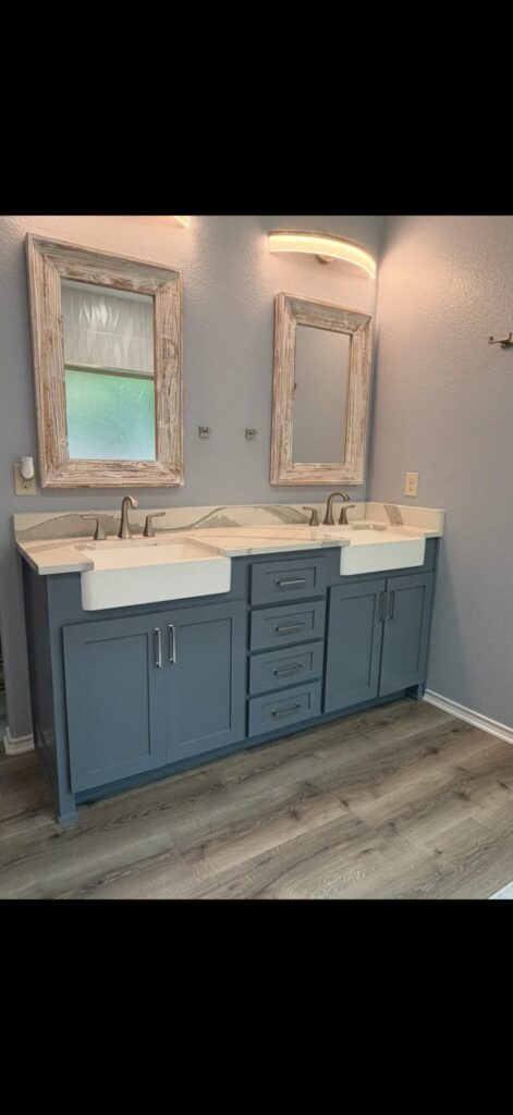 Slate blue double vanity with farmhouse sinks and rustic wood-framed mirrors, DFW bathroom remodel