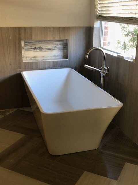 Square freestanding tub with dark wood-look tile surround