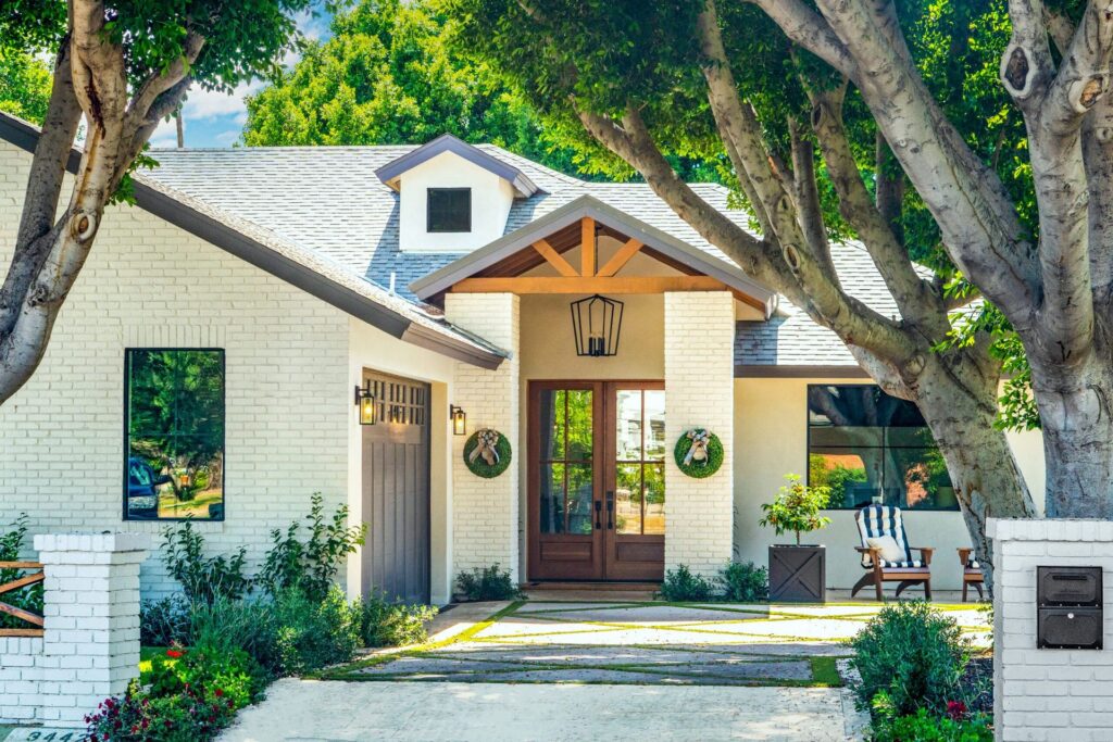 Whole home renovation in DFW: white brick home with cedar front porch and landscaped walkway